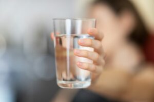 person holding out glass of water